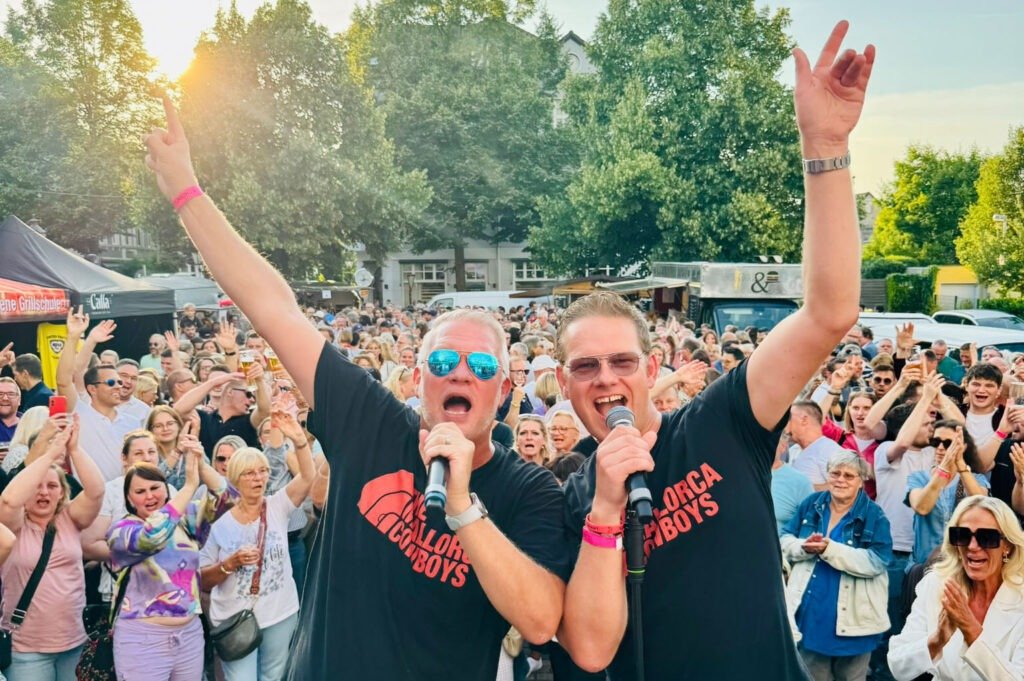 Zwei Sänger vor jubelndem Publikum